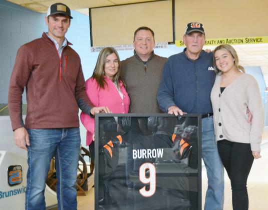 LANE MEYER of Johnson, left, had the highest bid on the Joe Burrow autographed football jersey at the Plager for a Purpose event. He is pictured with, continuing to the right: Jennifer and Matt Parde, Matt’s father Wayne Parde, and Matt and Jennifer’s daughter, Addison. Ann Wickett/Chieftain