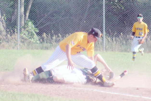 HUNTER BOHLING, Tecumseh Juniors second baseman, goes for the tag in a close play.