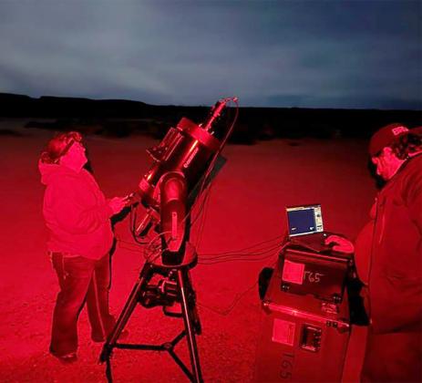 KENDRA MATKINS of Sterling, left, and a teammate set up to take readings of the orbit of the Palemele asteroid and Shawn moon from a beach at the north end of San Felipe, Baja California.