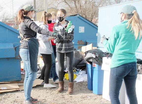 LEAH MEYER, left, with the Nebraska Recycling Council shows Kaita Baird where to put plastic bottles she has sorted out from the recycling bin’s contents on Friday, November 20.