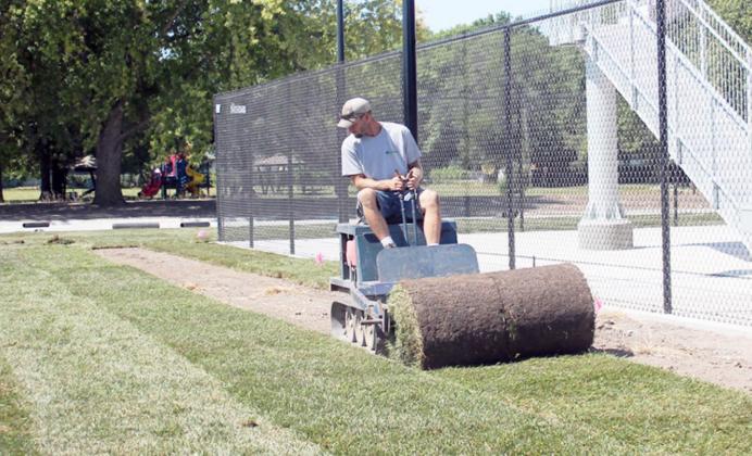 SOD IS ROLLED OUT on the south side of the new Tecumseh Aquatic Center by a crew member from Turf Pros, Inc. of Mead.