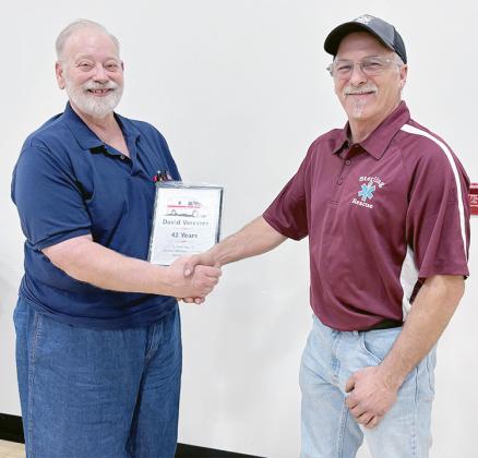 DAVID VERMEER, left, accepts a plaque for 42 years of service on the Sterling Rescue Squad from the captain of the rescue squad, his nephew Chris Vermeer. David is no longer an EMT, but still serves as a driver for the rescue squad and has a wealth of information to pass on to others.