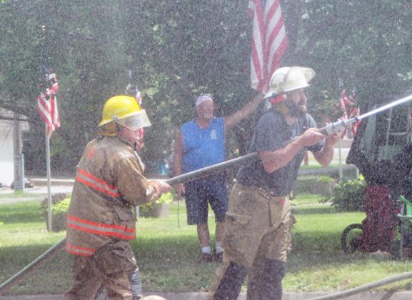 COOK FIREFIGHTERS Adam Badberg, left, and Matt Sherman compete in the Waterfights sponsored by the Cook Fire Department during Cook Days on Sunday, July 17. Ann Wickett/Chieftain