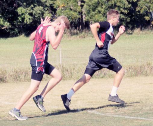 JASON KETTELHAKE passes a competitor from Elmwood-Murdock-Weeping Water in the cross country meet on Friday.