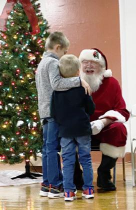 WHEN THE JOLLY OLD ELF IS KIND OF SCARY, it’s nice to have your big brother to lean on. Caleb Griess, right, was happy to have the support of his big brother Jacob, left, when it was his turn to visit Santa at the Tecumseh Community Building Sunday evening. They are the sons of Marcus and Katie Griess of Tecumseh.