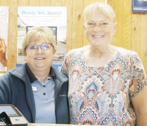 NEW TECUMSEH POSTMASTER LADDIE HELMS, right, with Diane McDonald, postal clerk.