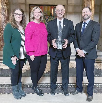 SENATOR MYRON DORN, second from right, holds the George Norris Award. He is flanked by Center for Rural Affairs Policy Director Johnathan Hladik, right, and his daughter Erin Dorn of Adams, who is a PA at the Beatrice Hospital. At far left is Dorn’s niece, Anna Dorn Wolken, also of Adams.