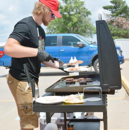 TREY HOLTHUS grills hamburgers outside Kerner Ace Hardware on Saturday, July 1 to kick off the 4th of July weekend.