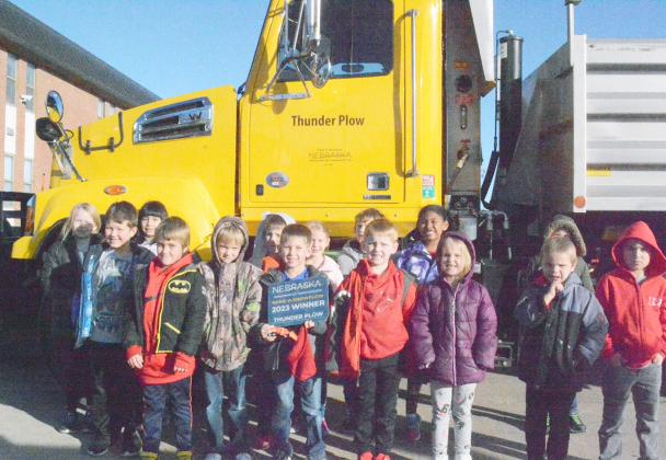 BEN GOTTULA, center, holding the winner’s plaque, and his first grade class from Johnson County Central Public Schools got to explore the Nebraska Department of Roads snow plow that Ben named “Thunder Plow” as the winner of the Nebraska Department of Transportation’s 2023 Naming of the Snow Plow Contest.