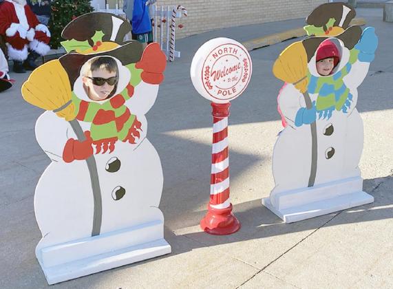 WYATT SHELTON, LEFT, AND HENRY THIES had fun putting their faces in the snowman cutouts at Santa’s visit to Sterling on Saturday, December 19. Carol Sisco/Chieftain